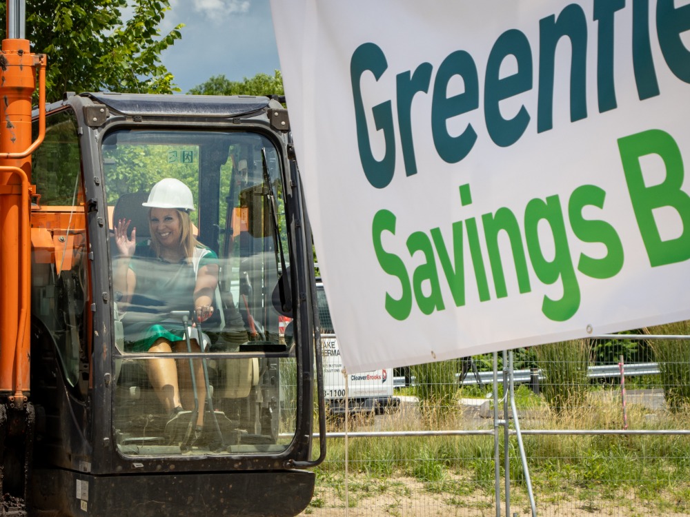 Greenfield Savings Bank's COO Shandra Richardson sits at the controls of an excavator