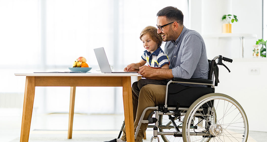 a father and his son looking at a laptop