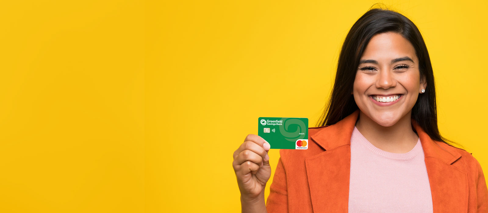 A smiling woman hold a GSB debit card