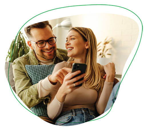 a young couple look at a phone the woman is holding. 