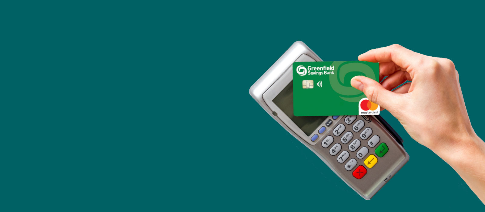 A woman's hand holding a GSB debit card over a card reader