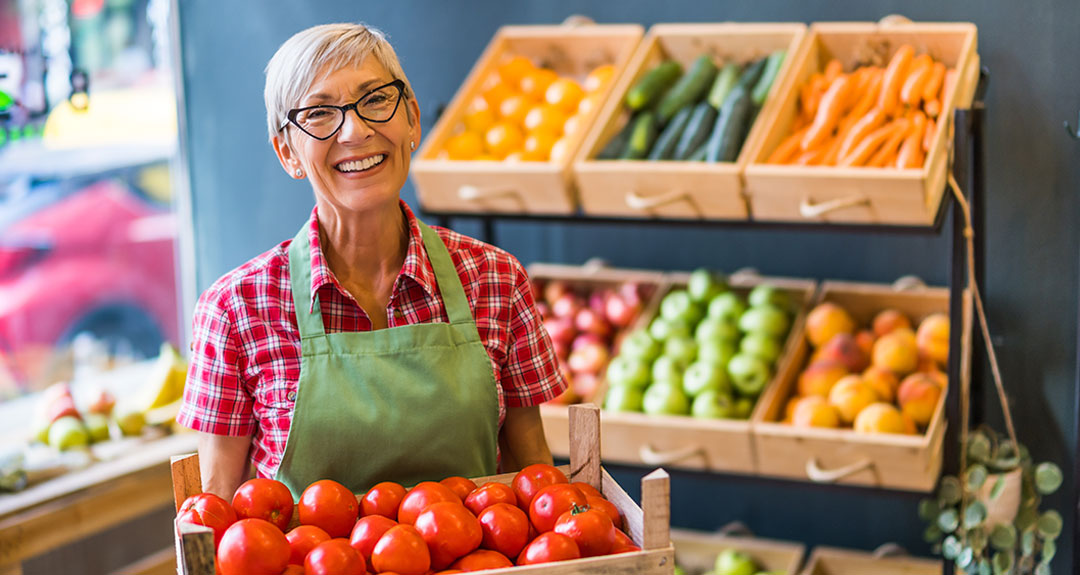 a woman holding a box of vegetables
